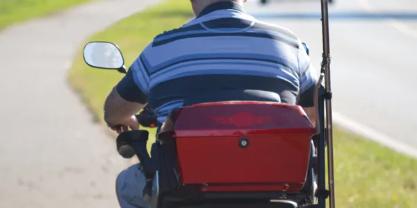 Person riding a mobility scooter outdoors