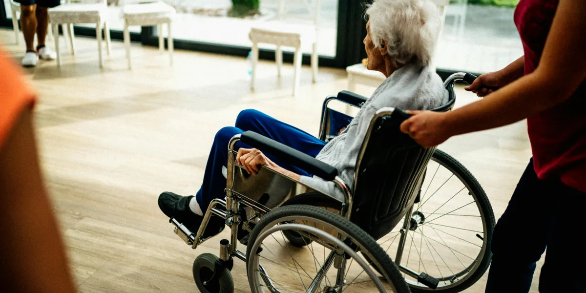 Senior in a wheelchair with a caregiver